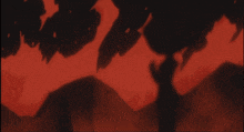 a red and black background with a few trees in the foreground