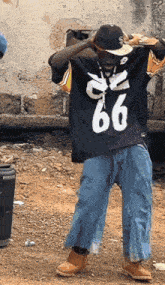 a man wearing a jersey with the number 66 on it is standing in the dirt