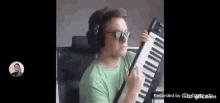 a man is wearing headphones and sunglasses while playing a keyboard .