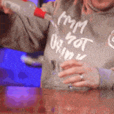 a person is pouring a drink into a glass while wearing a shirt that says i 'm not drinking
