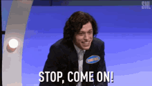 a man in a suit and tie is smiling and says stop come on .