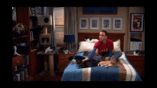 a man is sitting on a bed with cats and a poster that says ' chicago ' on it