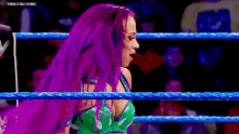 a woman with purple hair is standing in a ring .