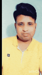 a man wearing a yellow shirt has a sticker on his face that says ' e ' on it