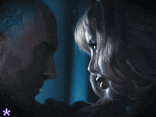 a man and a woman looking at each other with a purple star in the background