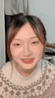 a close up of a woman 's face with a white sweater on