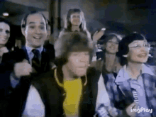 a group of people are standing next to each other and smiling in a room .