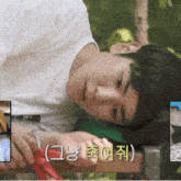 a young man laying on a bench with korean writing on the bottom right