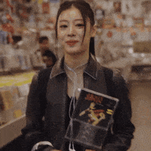 a woman in a leather jacket holds a cd case that says ' heavy ' on it