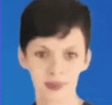 a blurry picture of a young man 's face with a blue background .