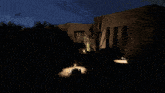 a house with a car parked in front of it is lit up at night