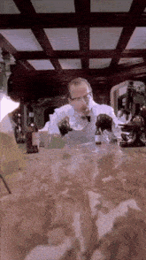 a man in a lab coat is pouring liquid into a bottle