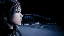 a woman with a nose ring is standing in front of a row of chess pieces