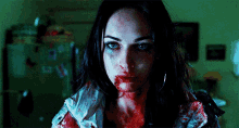a woman with blood on her face is looking at the camera in a dark room