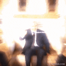 a blurry picture of a man in a suit and tie with the website gifrun.com visible in the corner