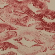 a close up of a lipstick on top of a piece of paper with a kiss .