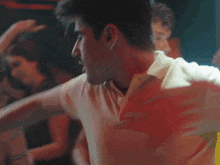 a man in a white shirt holds his arm in the air
