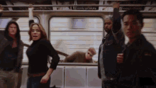 a group of people standing on a train with a sign above them that says twenty eight