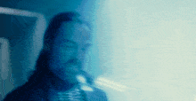 a blurry picture of a man in a suit and tie in a blue light