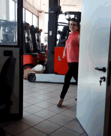 a woman stands in front of a forklift that says linde