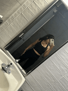 a woman is taking a picture of herself in a bathroom mirror