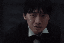 a group of men in tuxedos and bow ties are standing in front of a black wall with the time 04:24 on it
