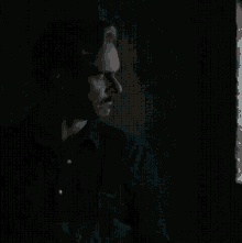 a dark room with a light shining through the window