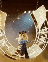 a woman in a cowboy hat singing into a microphone
