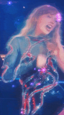 a woman is singing into a microphone on a stage with a blue background