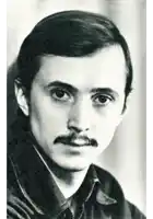 a man with a mustache is wearing a leather jacket