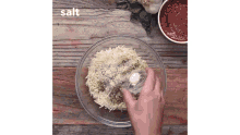 a person pouring salt into a bowl of cheese