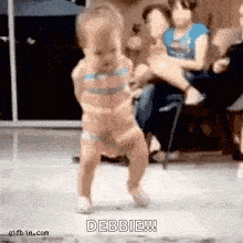 a baby in a diaper is dancing in a room .