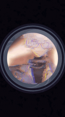 a painting of a person wearing glasses is displayed in a round frame