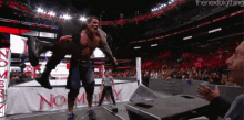 a man is carrying another man in a wrestling ring with a banner that says no way on it