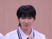 a young man wearing a white shirt and a tie smiles for the camera