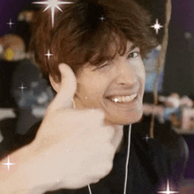 a man is smiling and giving a thumbs up while wearing headphones .