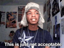 a man wearing a fur hat and a cowboys shirt says " this is just not acceptable "