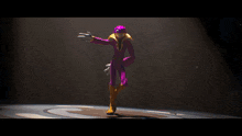 a cartoon character in a purple and yellow suit is dancing on a stage