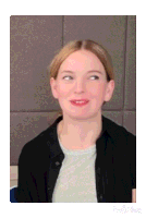a woman wearing a grey shirt and a black jacket is looking up