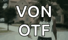 a man in a white tank top is standing in front of a house with the words von otf written above him .