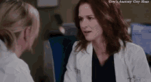two female doctors are talking to each other in a hospital room .