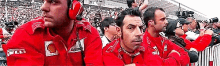 a group of men wearing red jackets with the word shell on them are sitting in a stadium .