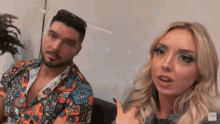a man and a woman are sitting next to each other and the man has a beard