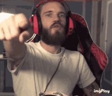 a man with a beard is wearing headphones and holding a tambourine while pointing