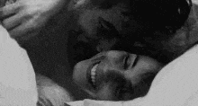 a black and white photo of a man kissing a woman .