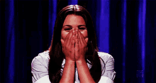 a woman applauds in front of a blue curtain that says divx on it