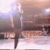 a man is dancing on a stage in front of a crowd .