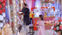a man and a woman are standing in a room decorated with flowers