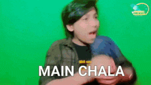 a young boy is making a funny face and says main chala in front of a green screen