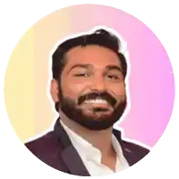 a man with a beard is smiling in front of a pink background